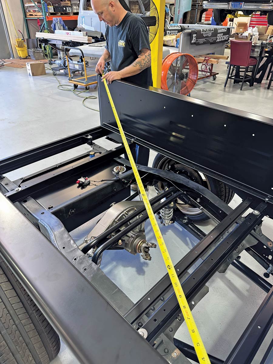 man holding yellow tape measurer diagonally to measure perimeter of truck bed