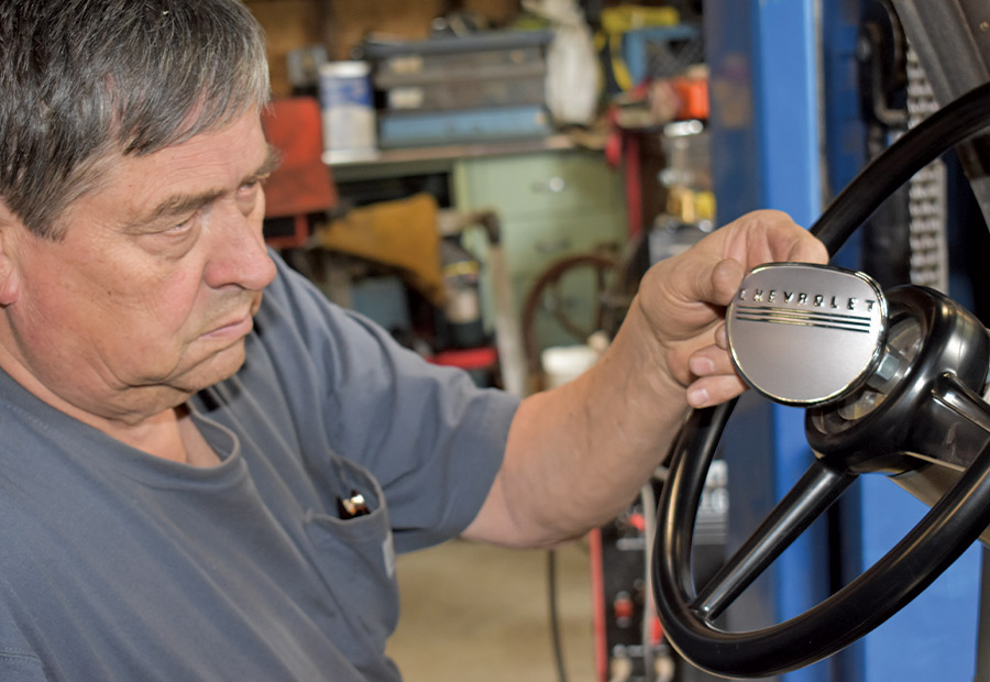 reproduction horn button being installed onto steering wheel