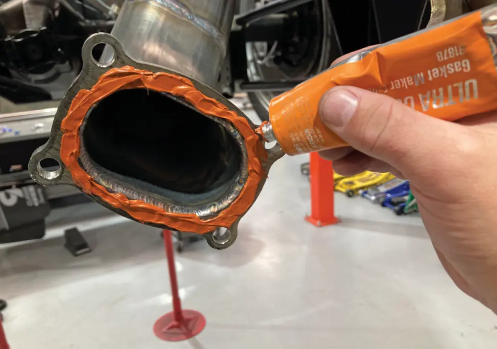 vibrant orange High-Temp RTV sealant is applied to a flanged surface