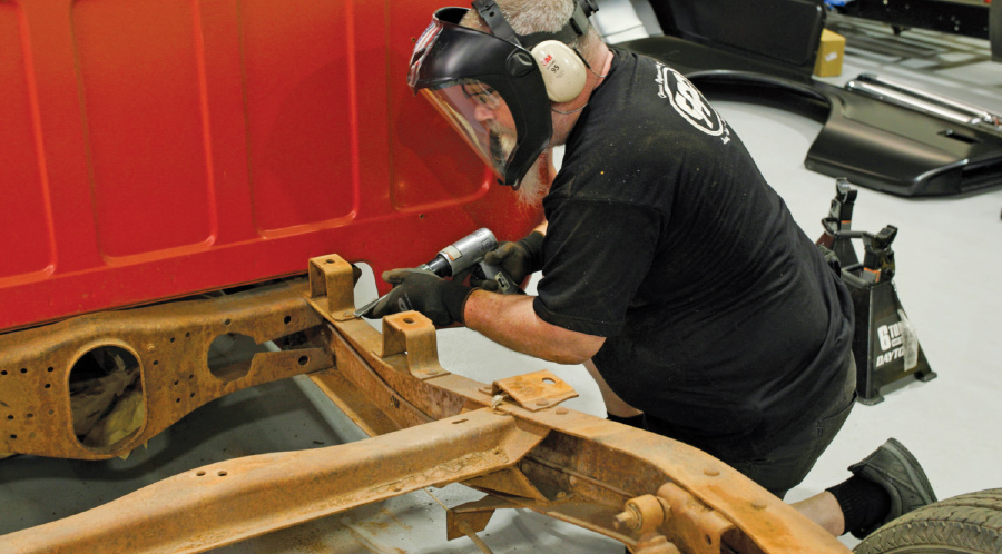 Gary Ash knocking the heads off the rivets holding the bed mounts in place