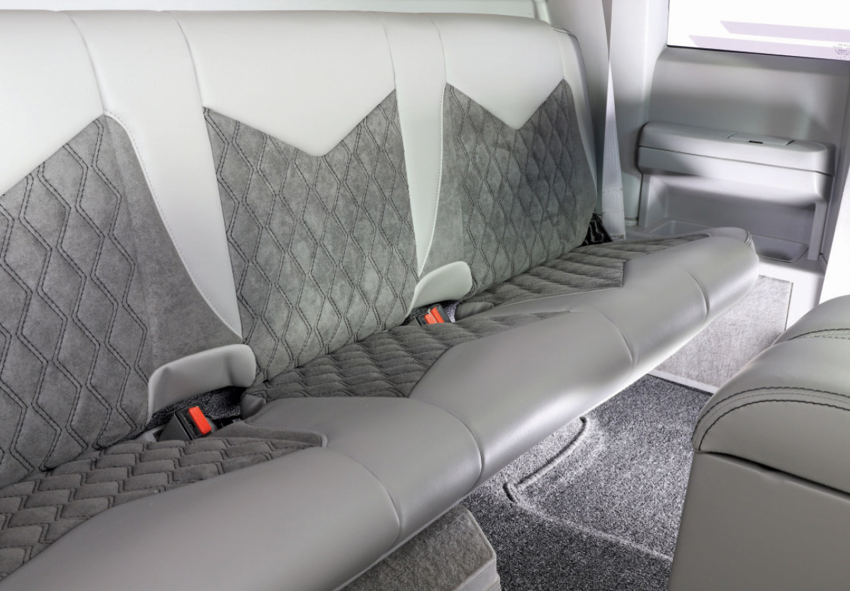 Rear bench seat of a 1990 Chevrolet C1500, showcasing custom diamond-stitched upholstery in gray and white tones