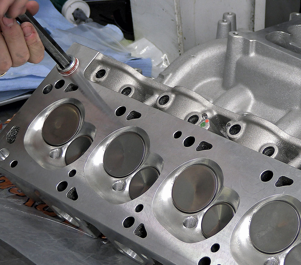 Tightening head bolts on an assembled Trick Flow cylinder head, with an Edelbrock intake manifold attached