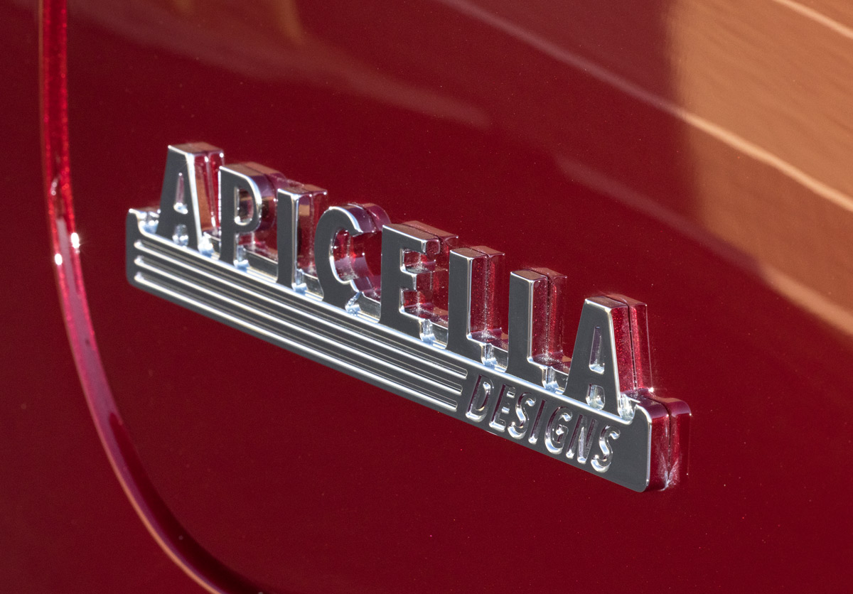 Close-up of Apicella Designs badge on custom red 1952 Chevrolet 3100