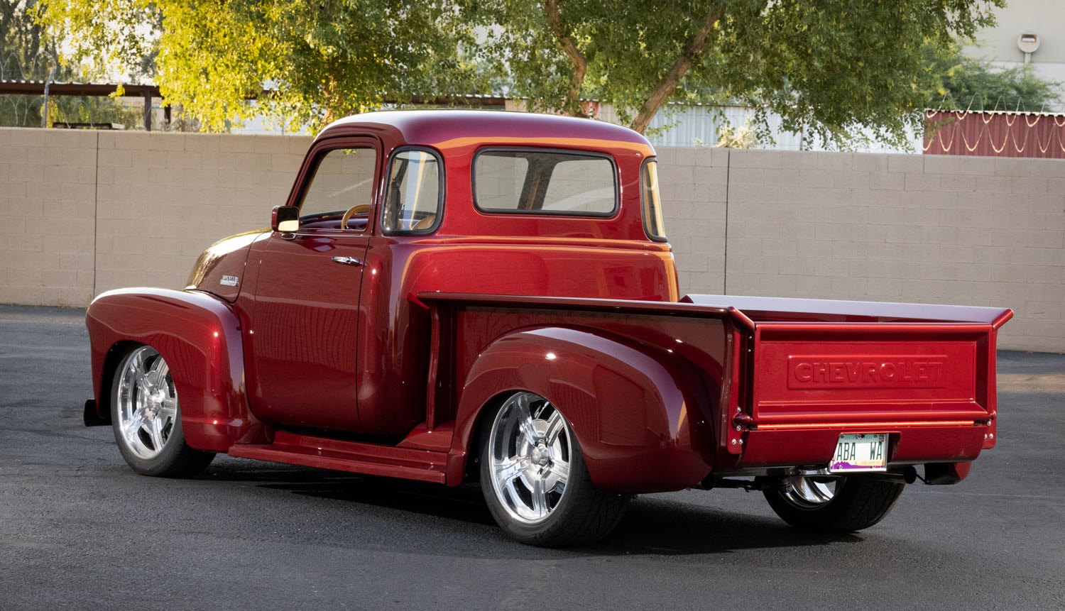 Rear view of 1952 Chevrolet 3100, custom red, lowered with modern touches, Chevrolet embossed tailgate