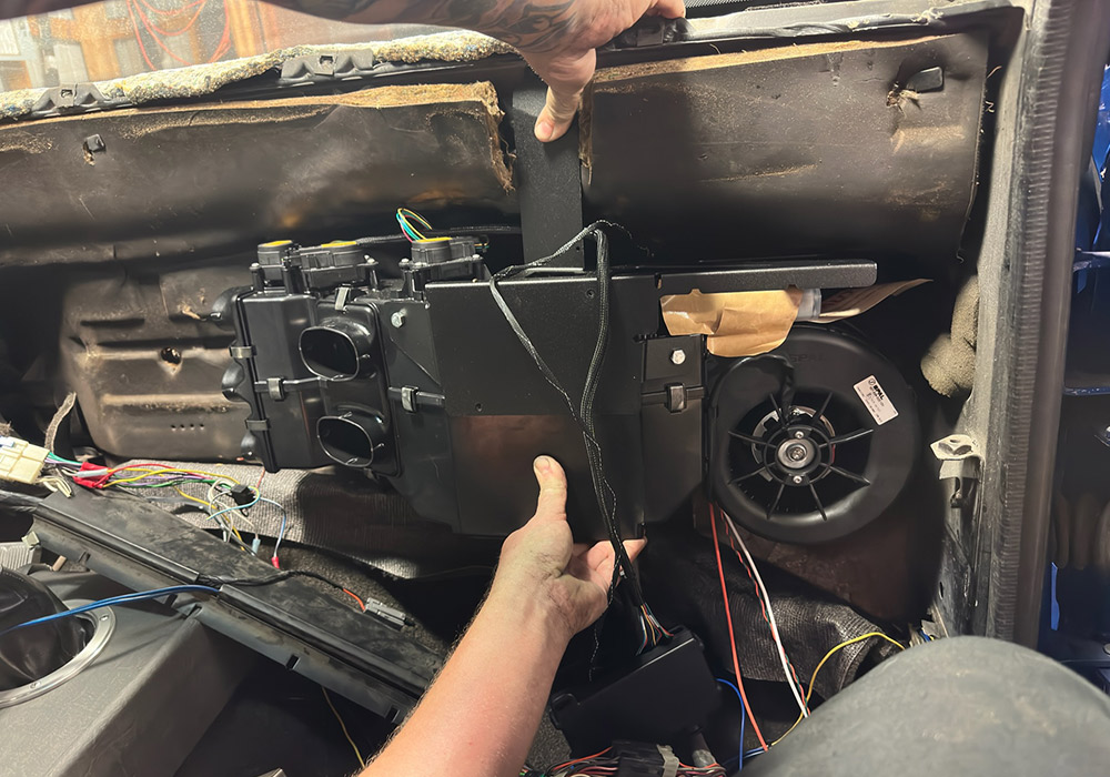 Installing the new air conditioning unit inside the dash of a 1990s Chevrolet CK 1500