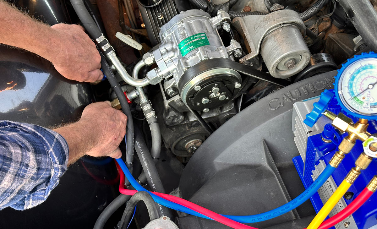 Connecting AC lines and performing a system check in the engine bay of a 1990s Chevrolet CK 1500