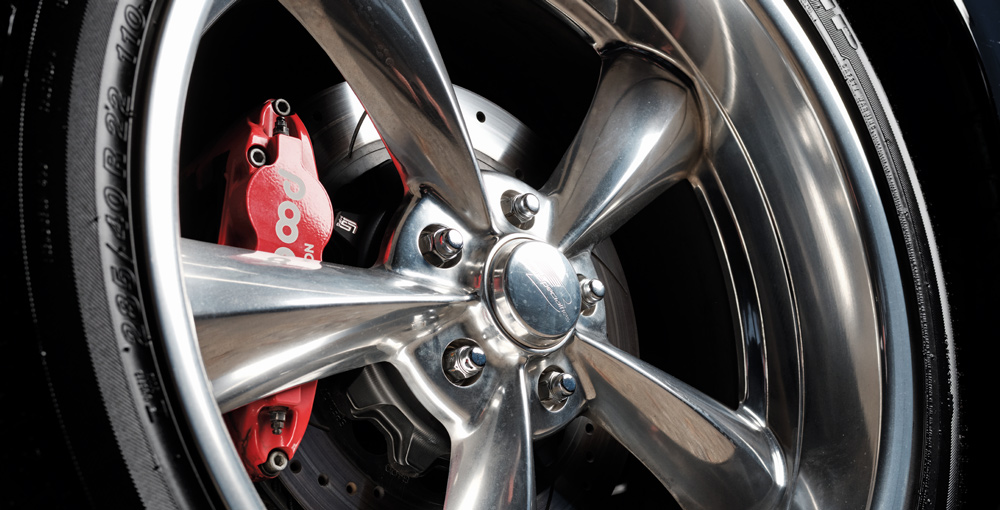 Close-up of polished chrome wheel with red Wilwood brake caliper on a custom GMC Sierra