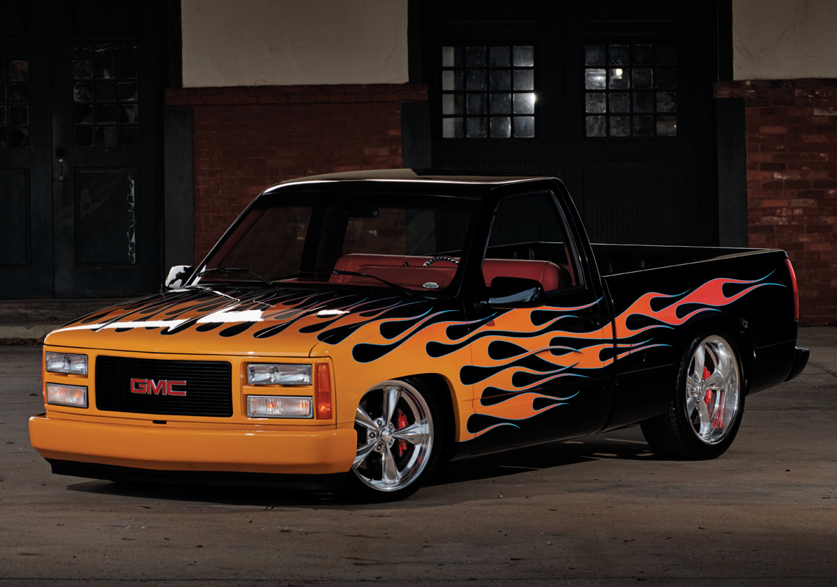 Front view of a black and orange flame-painted GMC Sierra with chrome wheels