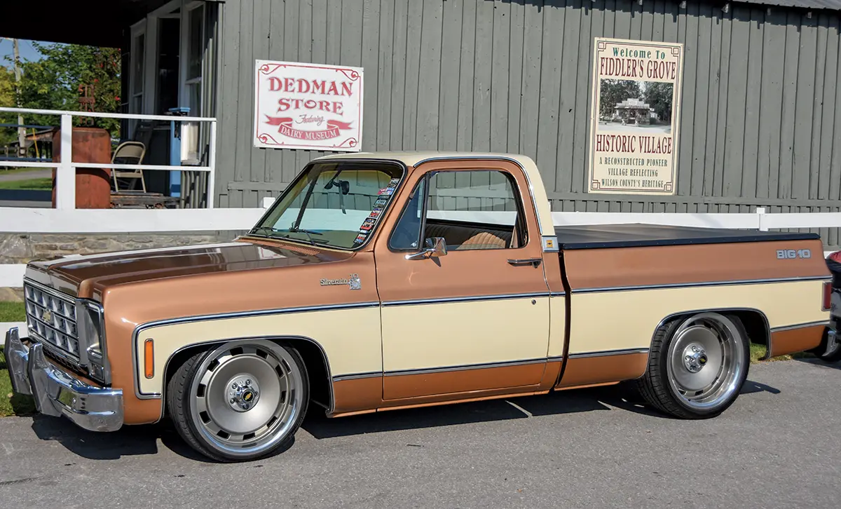 A 1977 Chevrolet C10 Big 10 in a two-tone brown and cream finish, with lowered suspension and modern wheels