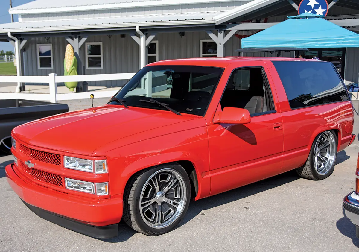 1995 Chevrolet Tahoe two-door SUV in bright red with custom wheels and a lowered suspension