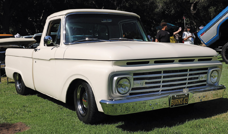 Pristine white 1963 Ford F100 with chrome bumpers at a car show