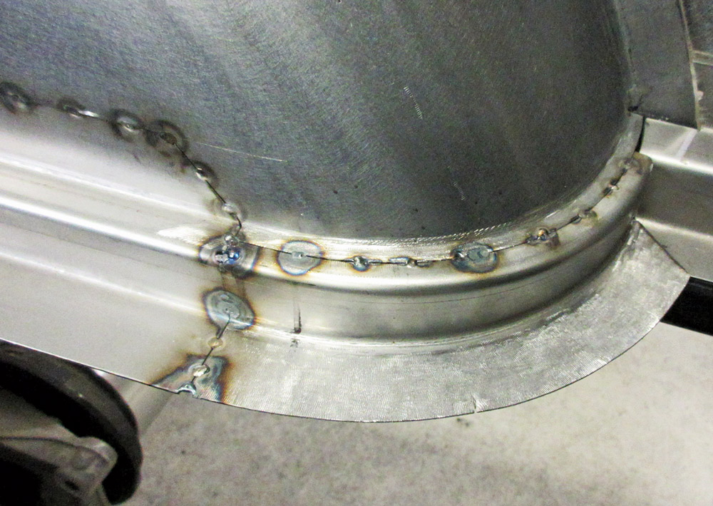 Spot welding the custom wheel tub onto the F-100 bed structure