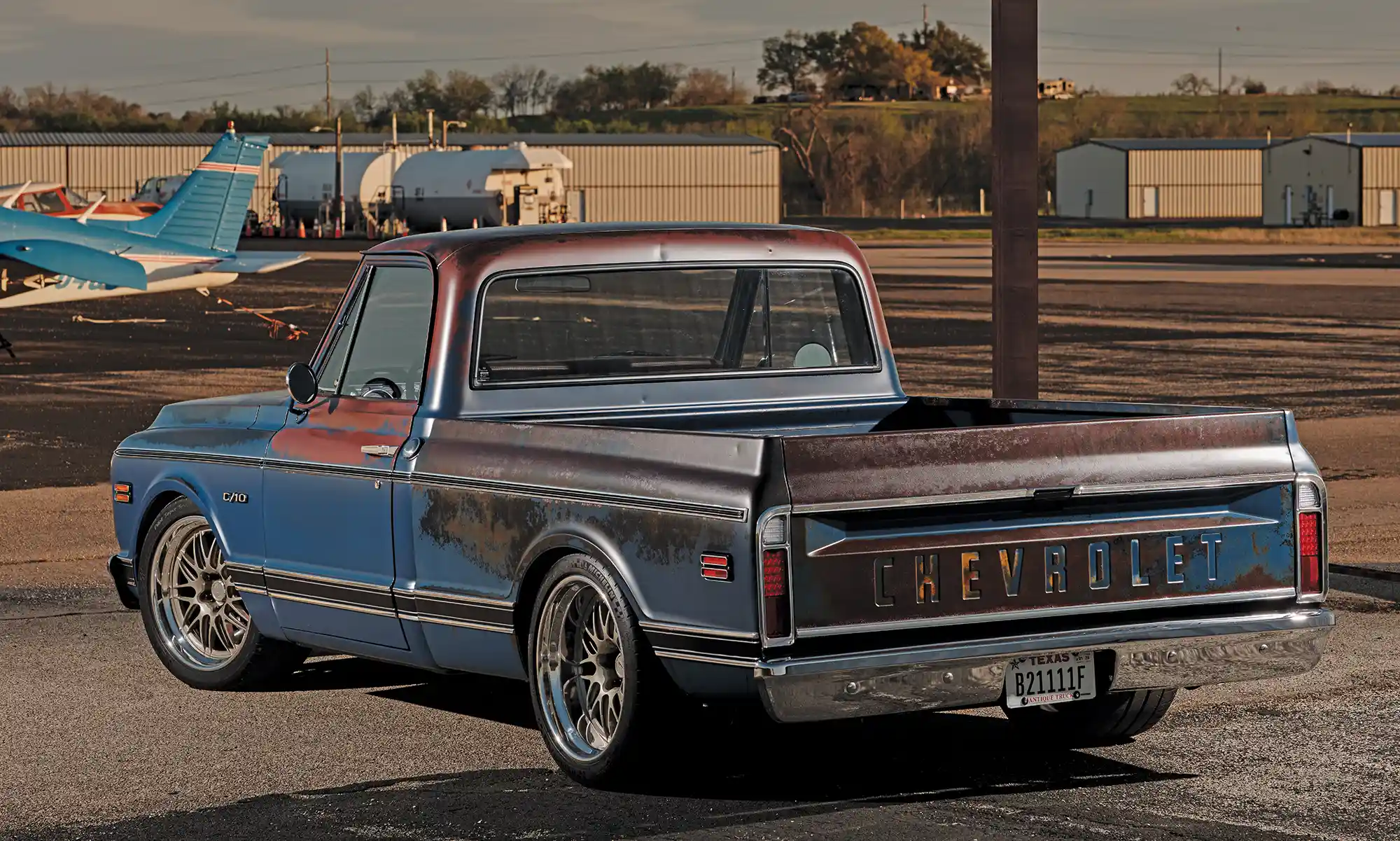 Rear view of 1969 Chevrolet C10 truck with custom wheels, parked at airport