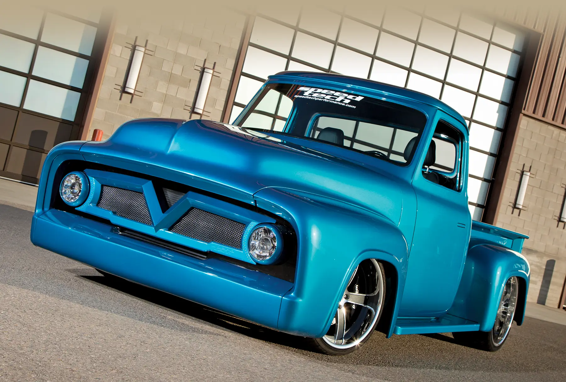 Front close-up of the blue 1954 Ford F100 focusing on its custom grille and round headlights