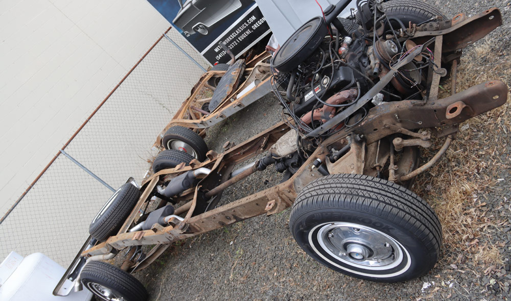 Disassembled Chevy K10 chassis with engine and drivetrain visible during restoration