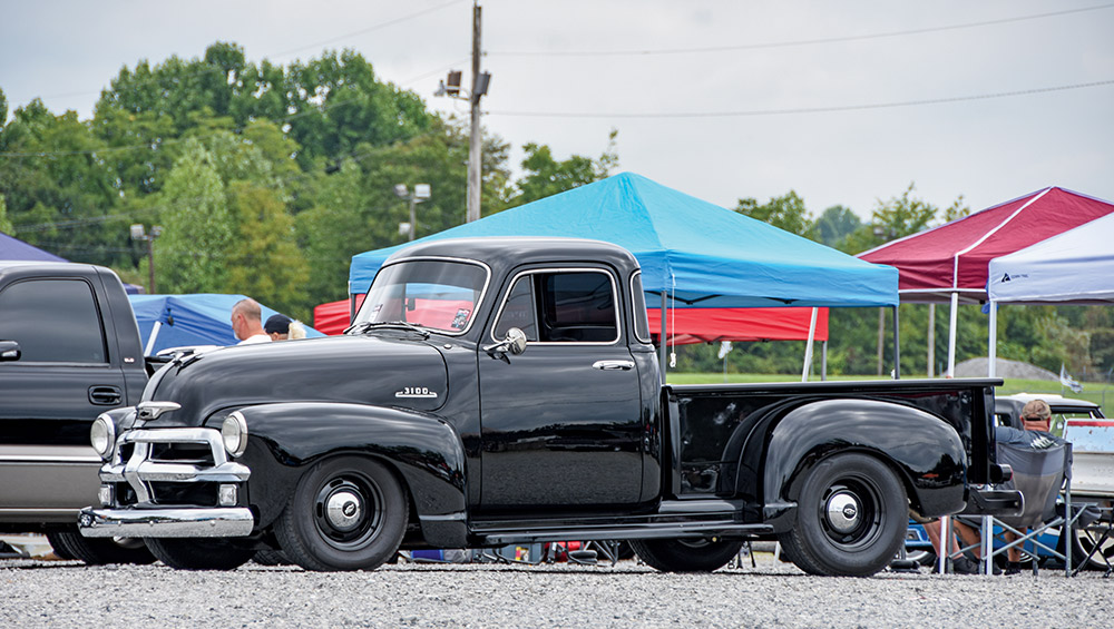 black Chevy 3100 truck with chrome bumpers, displayed at an outdoor event