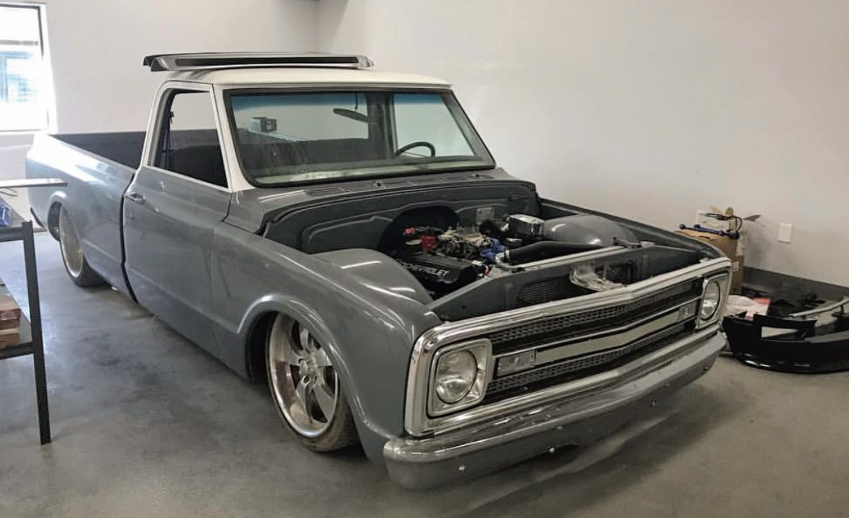 grey 1969 Fleetside C10 in garage with hood removed