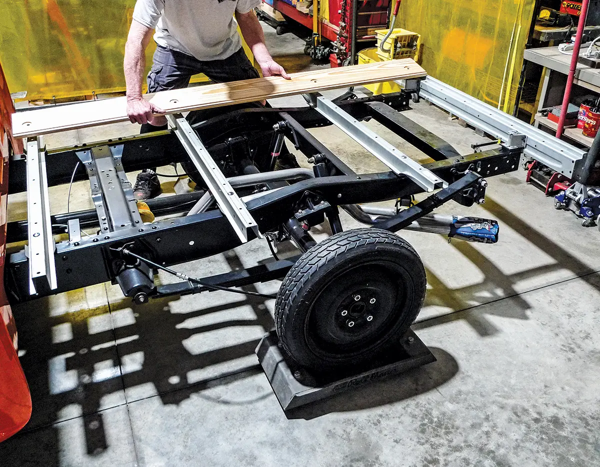 Placing wood planks on the truck bed frame for final layout