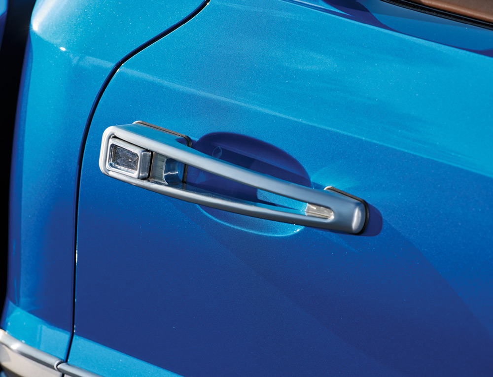 Polished chrome door handle on a vibrant blue 1969 Ford F100