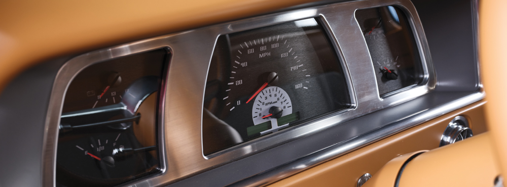 Classic dash gauges on 1969 Ford F-100 with tan leather and brushed aluminum detailing