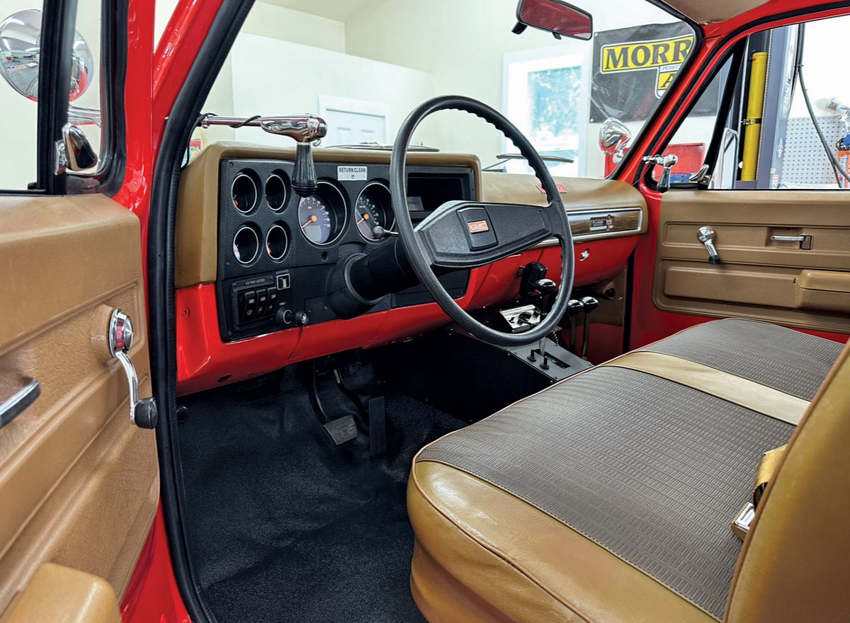 Restored tan and brown interior of 1979 GMC K2500 with vintage dashboard and bench seat