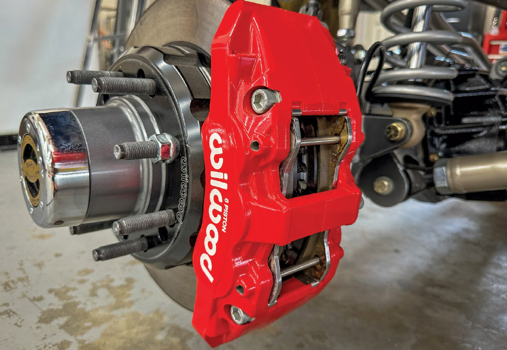 Detailed view of red Wilwood six-piston calipers on the GMC K2500’s high-performance braking system