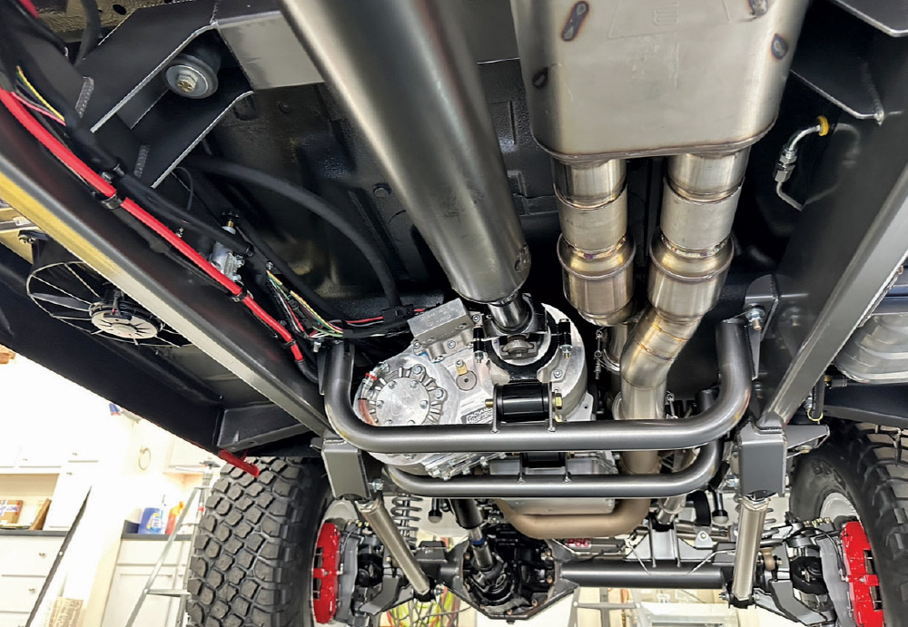 Underbody shot of GMC K2500 showing the robust transmission, custom driveshafts, and exhaust headers