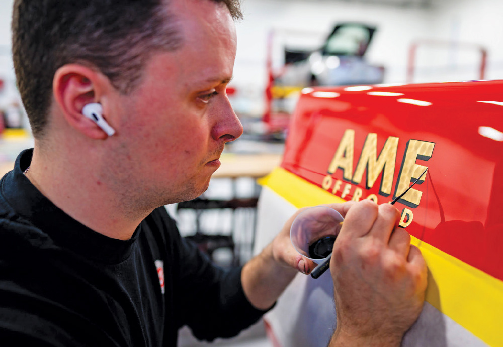 Precision hand-painting AME Offroad graphics on the GMC K2500 for authentic detailing