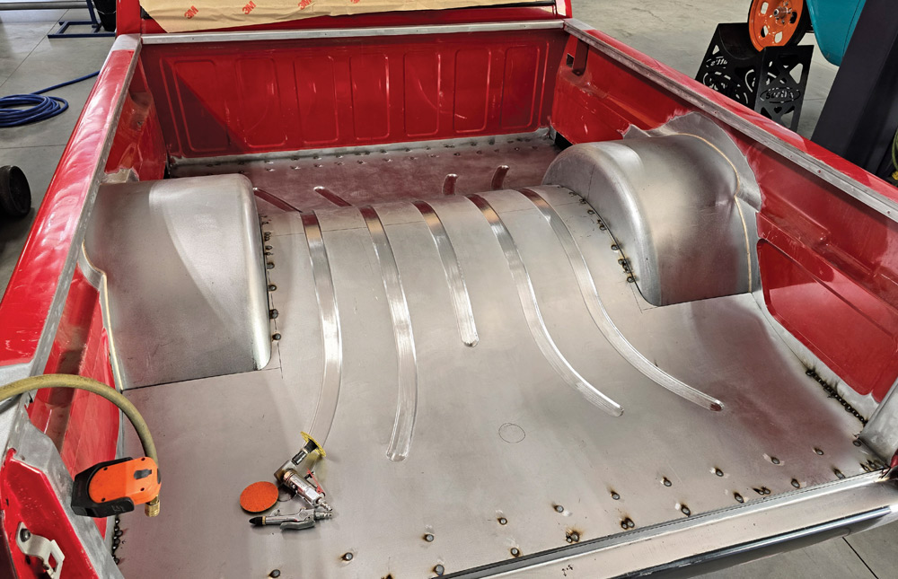 Progress on Chevy OBS bed showing metal tub shaping and floor reinforcement welds