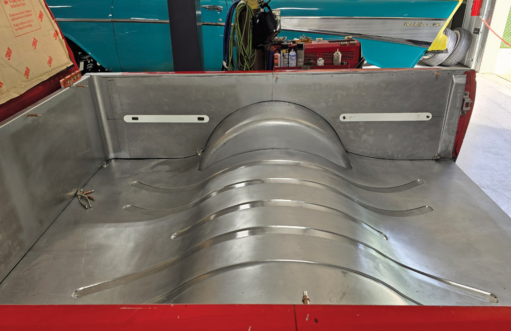 Custom sheet metal bed with contoured wheel tubs in a red classic Chevy truck