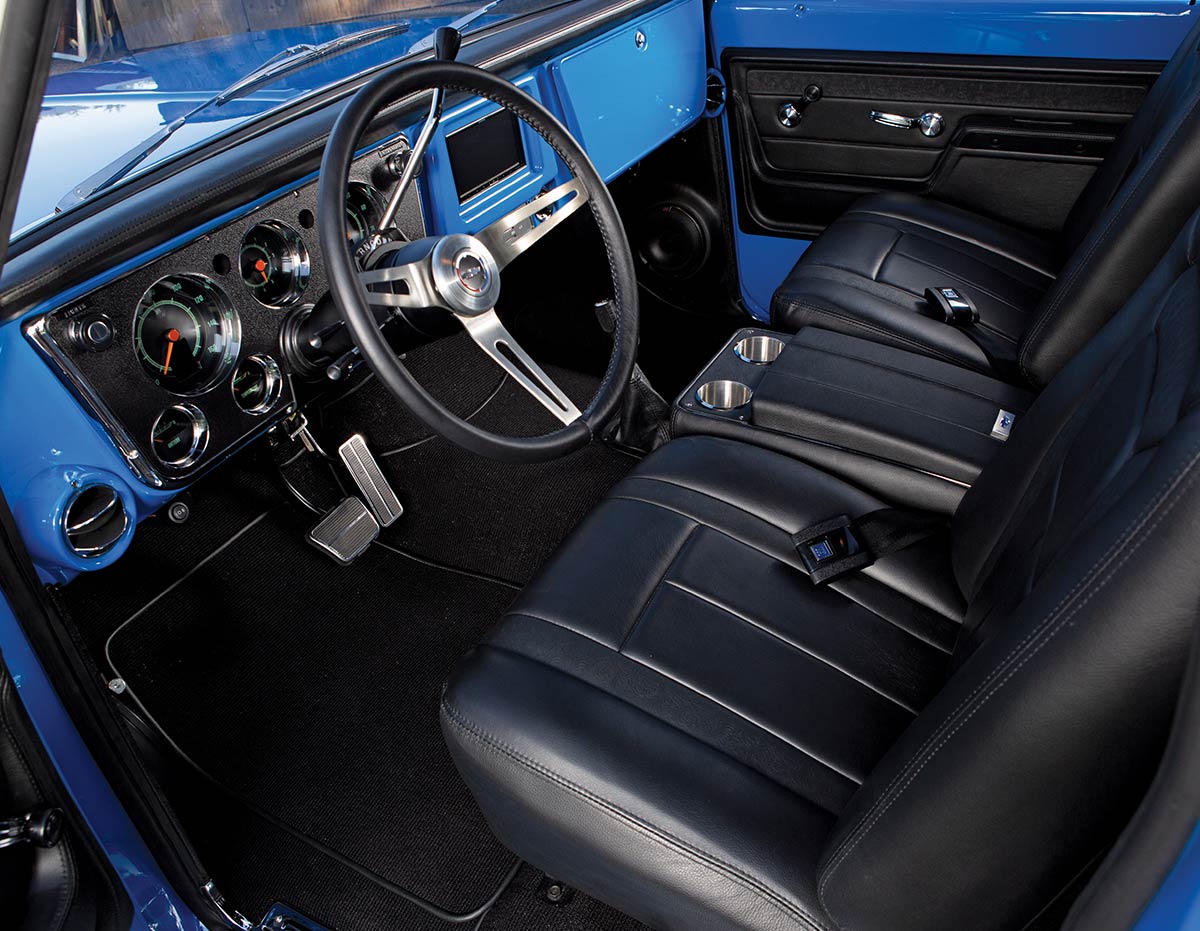 Close-up of 1972 Chevy K10 center console with black leather upholstery and stainless steel cup holders