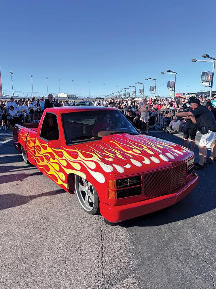 red 1988-98 Chevrolet CK truck with vibrant flame paint job, capturing attention at the show