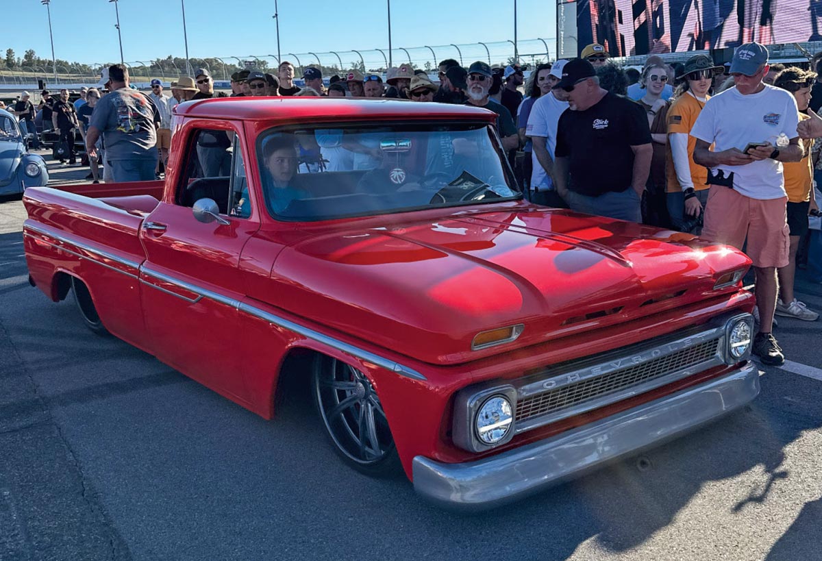 bright red 1966 Chevrolet C10 with custom wheels, drawing a crowd at the Triple Crown Truck Show