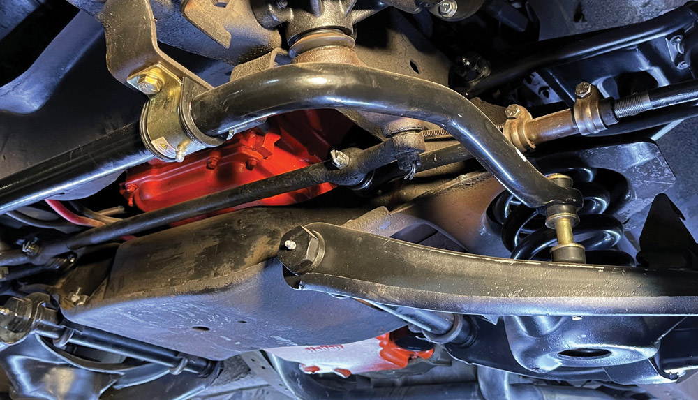 Installed IFS system under Chevy C10 with detailed view of sway bar, control arms, and crossmember integration