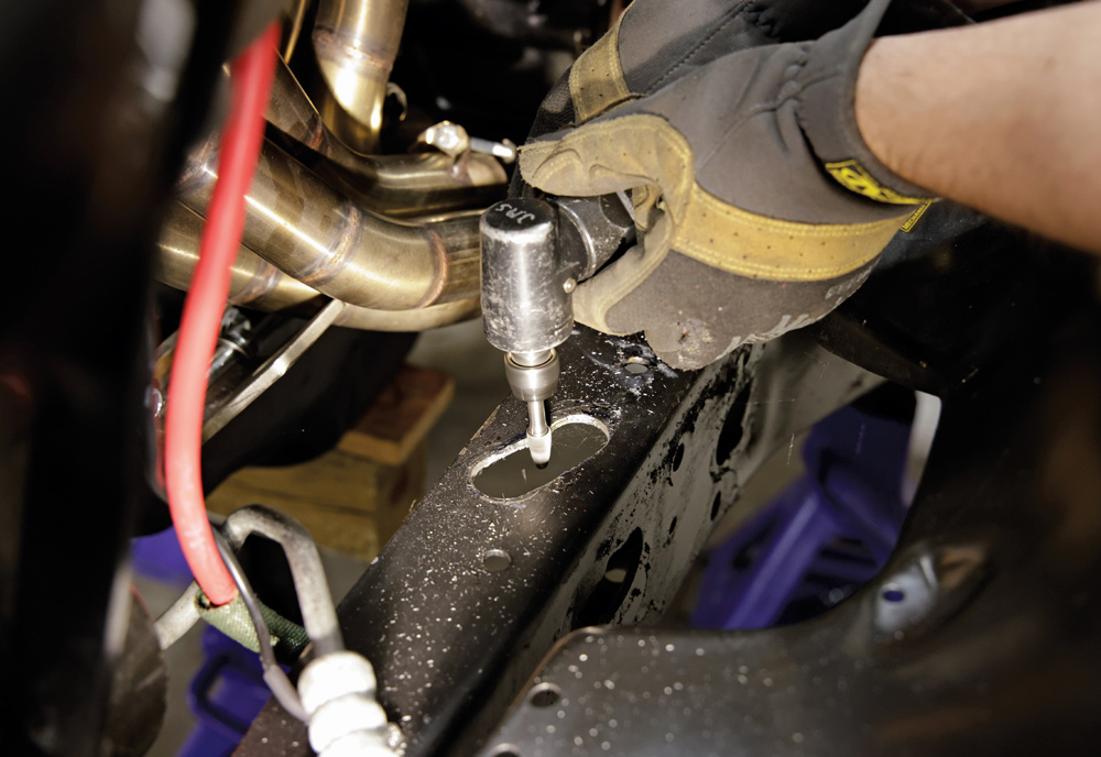 Smoothing drilled holes on frame rail for clean fitment of IFS bracket in Chevy C10 build