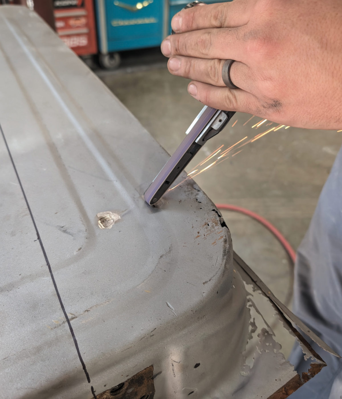 Filing edges with sparks flying during 1966 Chevy truck door panel refinishing