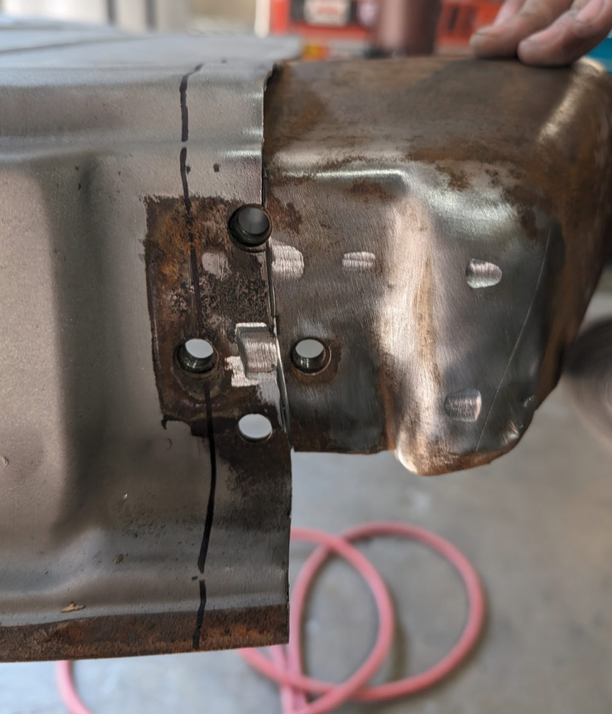Rusted 1966 Chevy truck door corner repair showing replacement panel alignment
