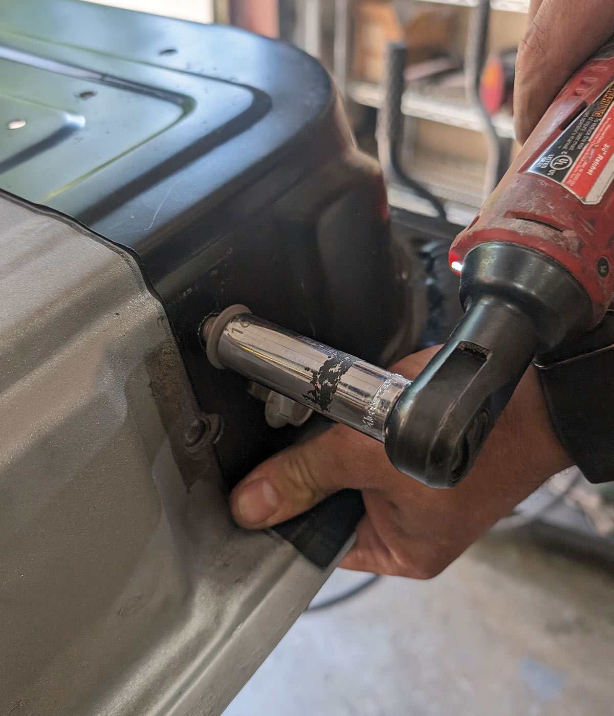 Power tool tightening fasteners on 1966 Chevy truck door corner panel