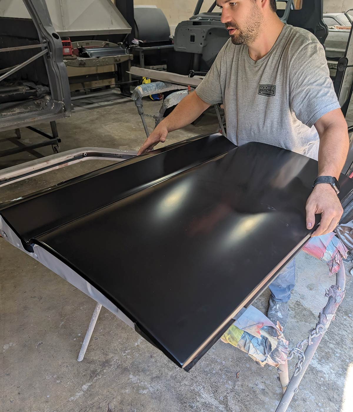 Inspecting black outer skin fitted to 1966 Chevy truck door during restoration