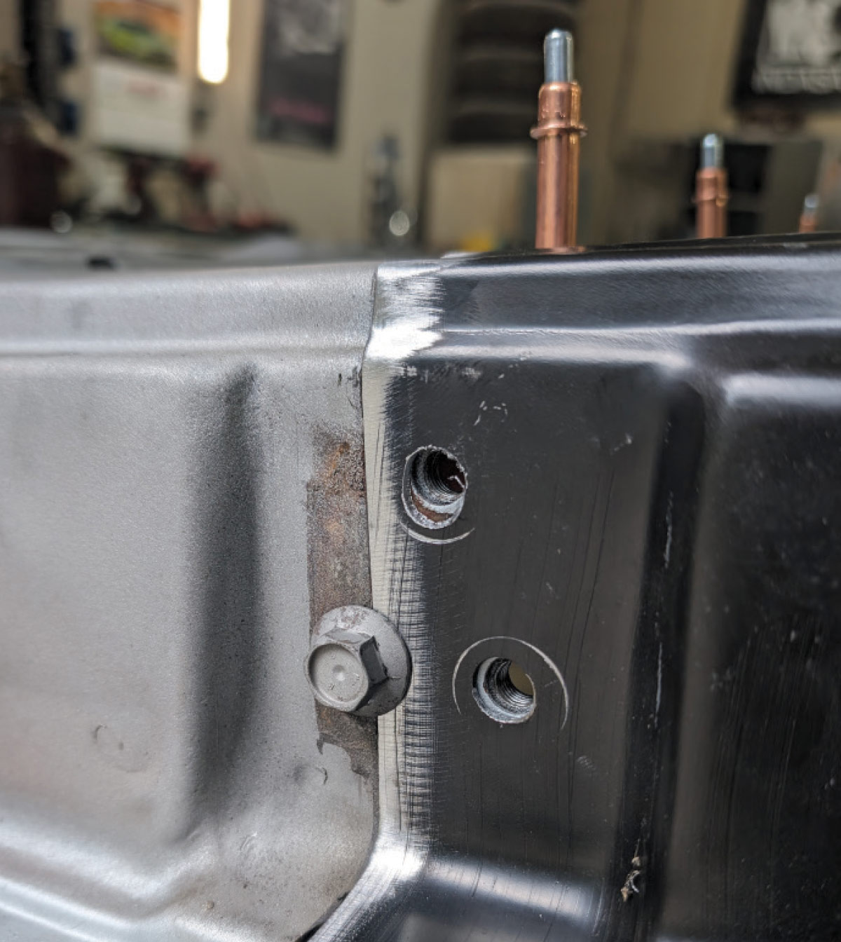 Close-up of Cleco fasteners aligning replacement panel on 1966 Chevy truck door