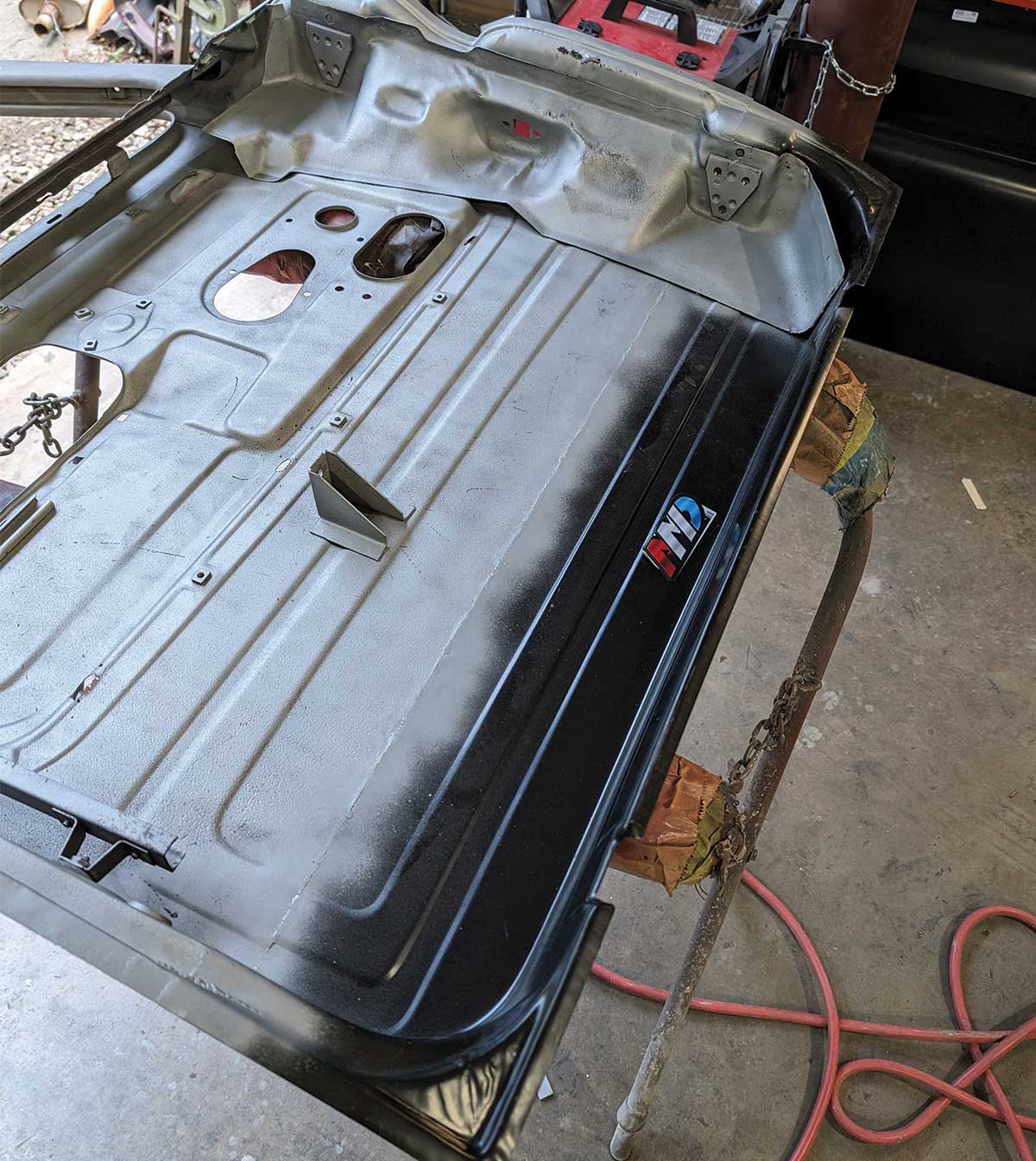 Completed weld and primed panel on 1966 Chevy truck door showing restored inner surface