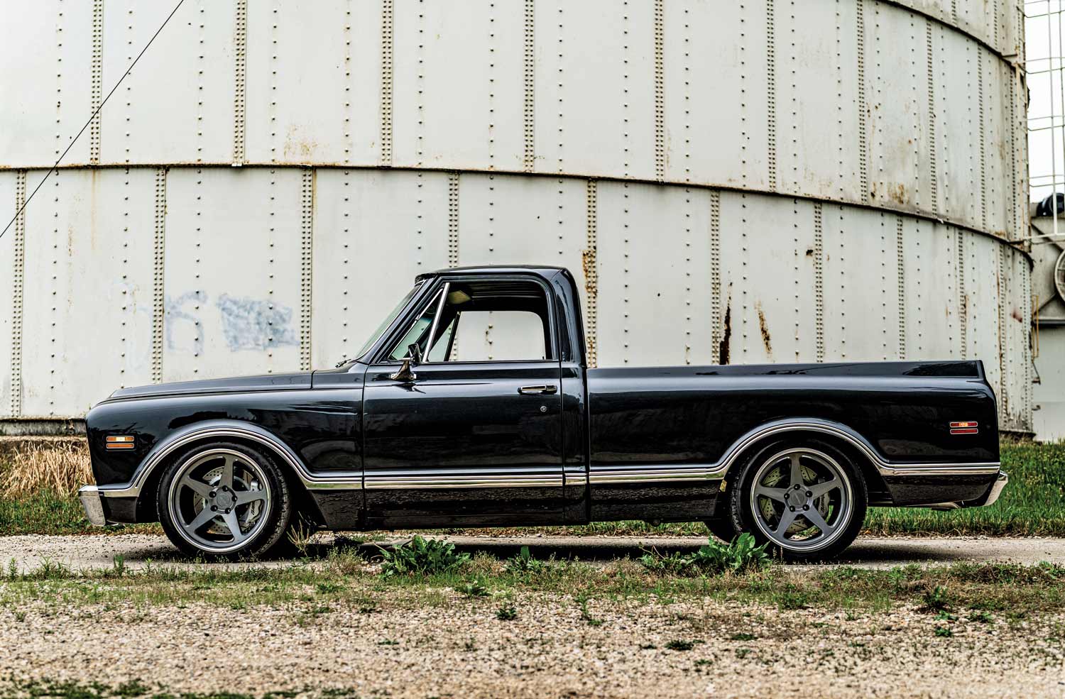 1969 Chevy C10 side profile featuring five-spoke custom wheels and sleek black finish