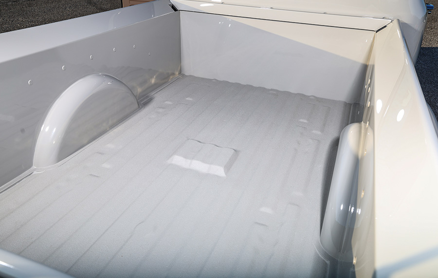 1956 Ford F-100 truck bed restoration showing smooth white paint, rolled edges, and inset wheel wells