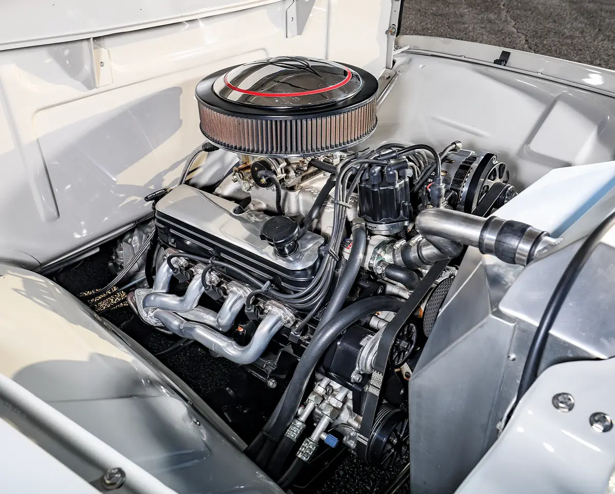 1956 Ford F-100 engine bay detail with aluminum radiator, braided hoses, and performance components