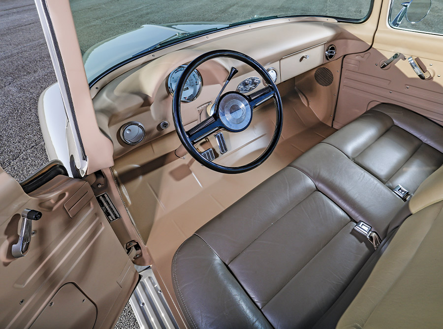 1956 Ford F-100 interior with tan leather dashboard, classic steering wheel, and restored bench seat