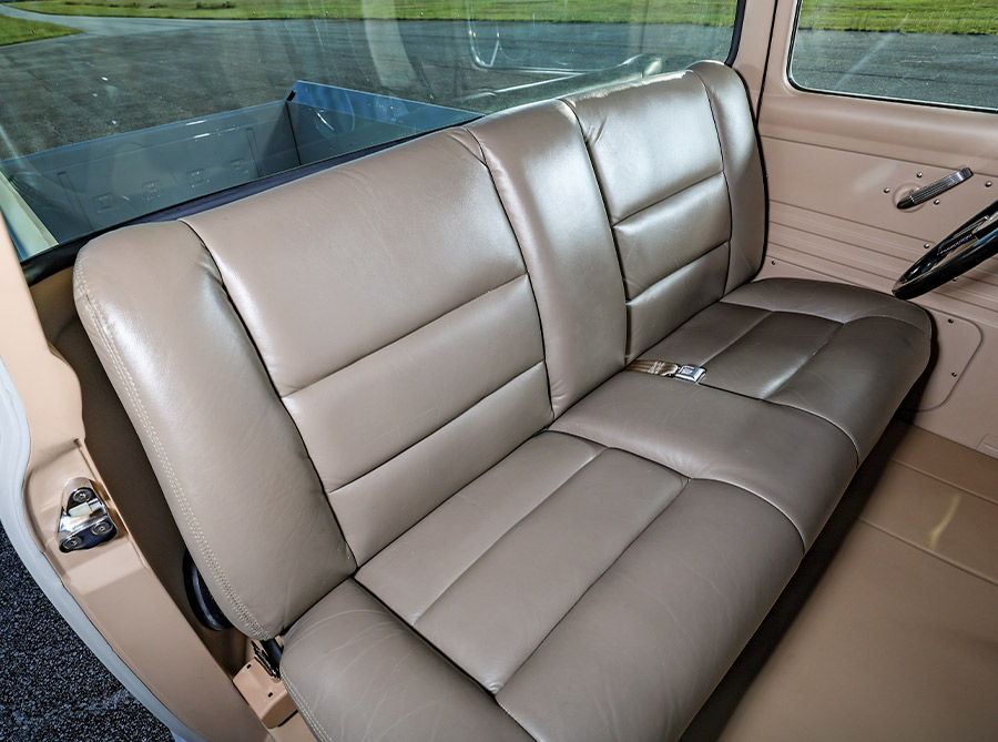 1956 Ford F-100 close-up of tan leather bench seat with modern stitching and polished hardware
