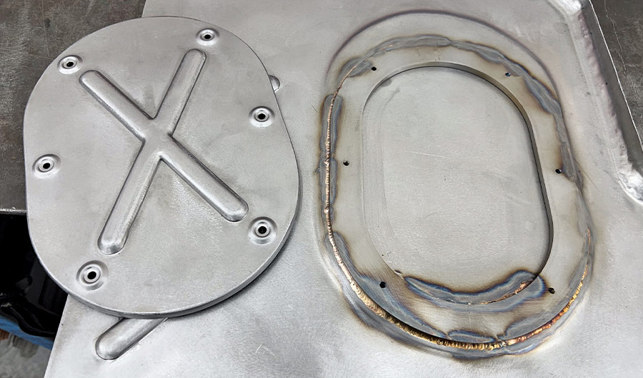 Custom bead rolled steel panel with TIG-welded oval cutout vintage car firewall