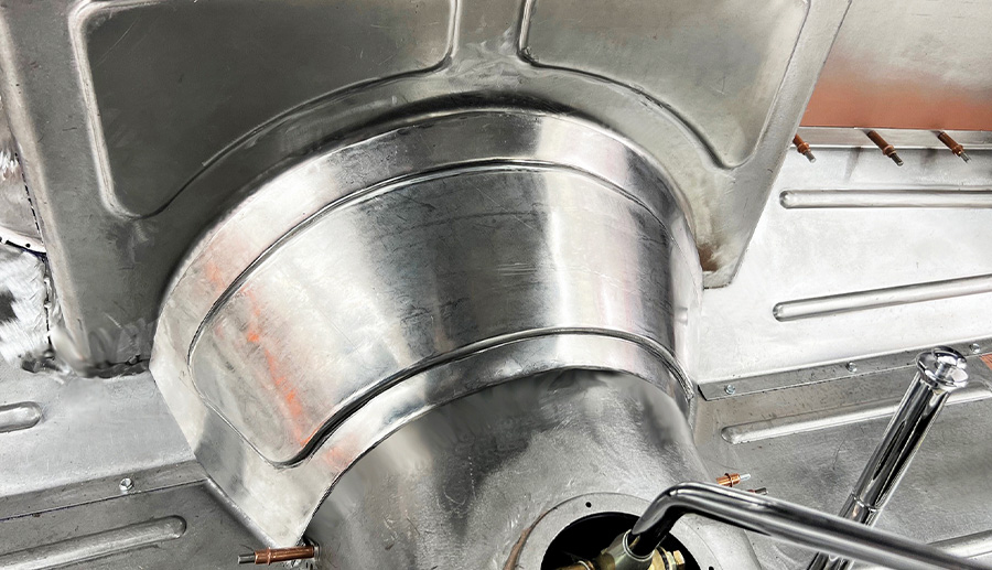 Detailed view of custom transmission tunnel and firewall curve integration vintage car fabrication