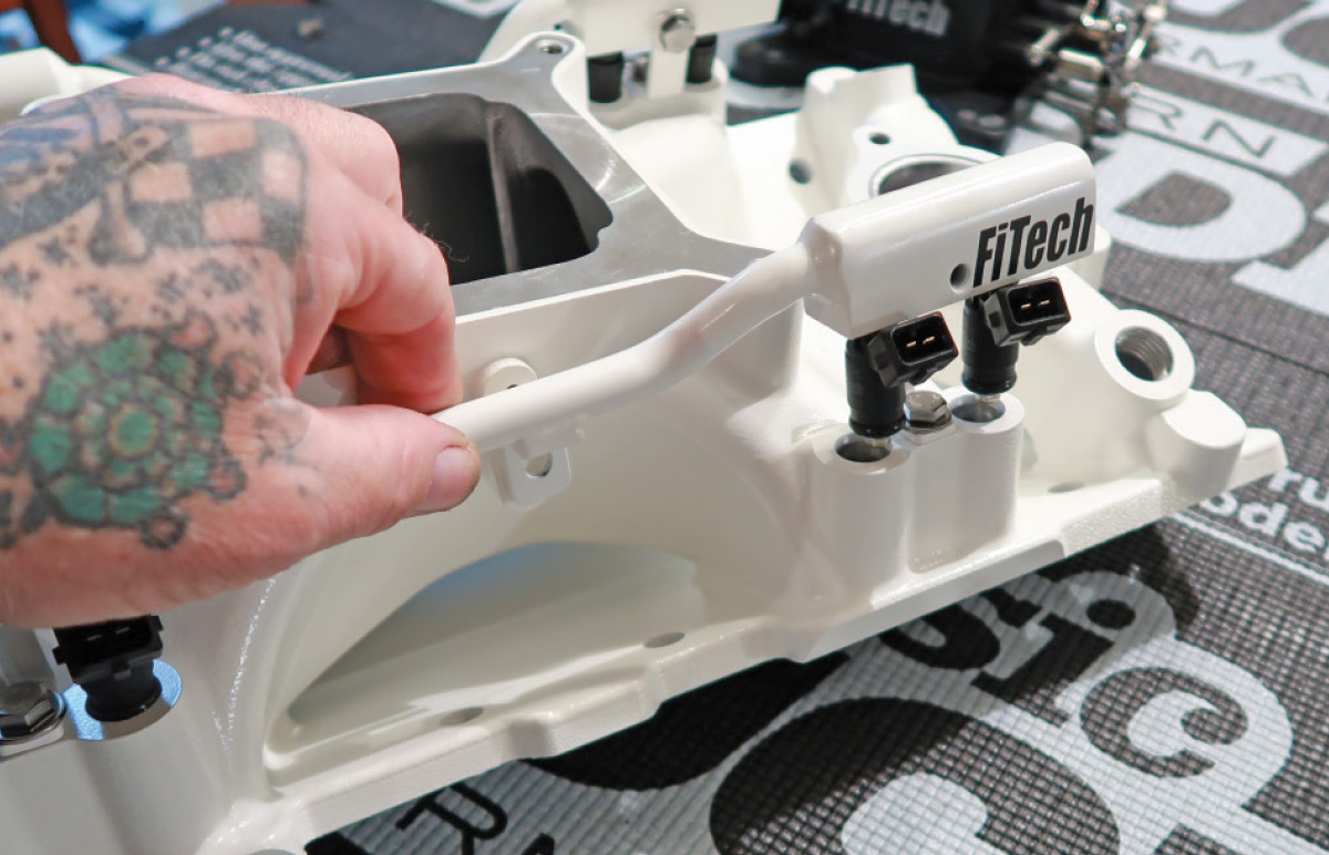 Installing FiTech Ultra Port EFI fuel rails onto the manifold for optimized fuel injection system setup