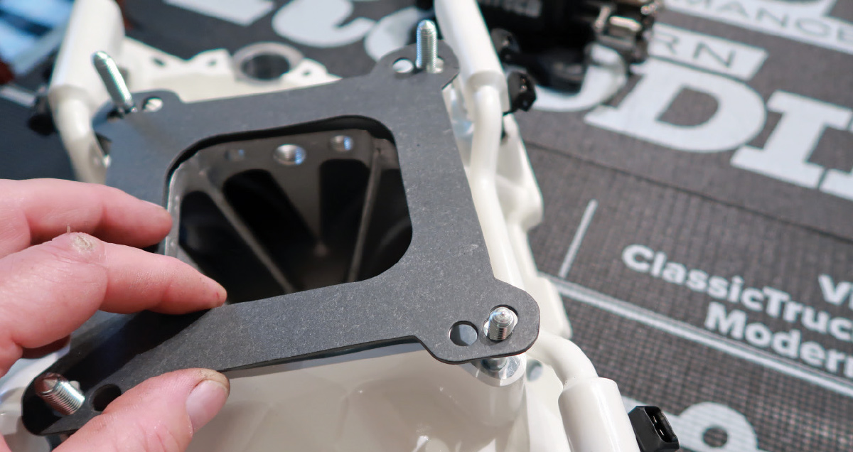Throttle body gasket placement on the FiTech intake manifold to ensure proper sealing during assembly